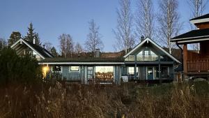 a large house with the lights on in front of it at Villa Laakson Helmi 1 с камином, сауной, SPA, на берегу озера in Himos
