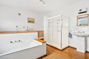 y baño con ducha, bañera y lavamanos. en Historic Home close to CBD 3Brm with views en Hobart