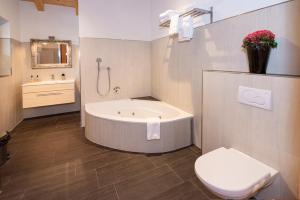 a bathroom with a tub and a toilet and a sink at Natural Deluxe Apartments Alpbach in Alpbach