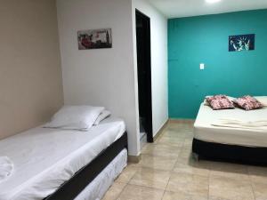 2 camas en una habitación de color azul y blanco en Aqua Lux, en Medellín
