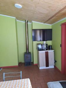cocina con fogones en una habitación con paredes verdes en Cabaña a pasos de la Playa, en Puerto Montt