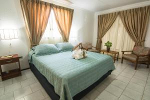 a bedroom with a bed with a stuffed animal on it at Hotel Hotu Matua in Hanga Roa