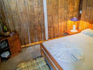 a bedroom with a bed and a table with a lamp at Palomino EcoHouse & Camping in Palomino