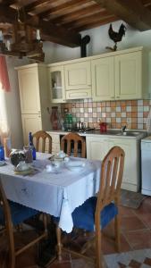 a kitchen with a table and chairs and a kitchen with white cabinets at Boscodisotto in Rapolano Terme