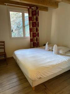 Schlafzimmer mit einem großen weißen Bett und einem Fenster in der Unterkunft Appartement T3+Mezzanine CHARLOTTE in Courchevel