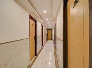 a corridor of a hotel with marble floors and doors at OYO Townhouse 843 Stay Inn in New Delhi