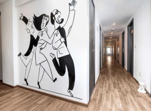 a wall mural of two women dancing in a hallway at OYO Townhouse 843 Stay Inn in New Delhi