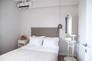 a bedroom with a white bed with white pillows at Cos Seafront Apartments in Gerakini