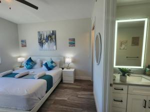 a bedroom with two beds and a sink and a mirror at Lux place and cozy 3Beds 2Rooms enjoy life in WPB Gym, EV Station Nearby the downtown and beaches in West Palm Beach