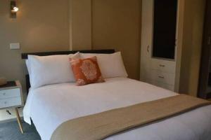 1 dormitorio con 1 cama blanca grande y 2 almohadas en Modern 1 bed-walk Casino riverfront 5 mins to CBD en Hobart