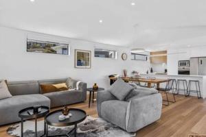 a living room with two couches and a kitchen at Mountain View Villa-close to shops-10min to CBD in Bellerive