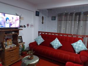 - un salon avec un canapé rouge et une télévision dans l'établissement Killitas home&apart, à Cusco