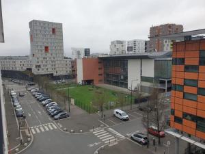 un estacionamiento con autos estacionados en una ciudad en Superbe appartement Evry Centre, en Courcouronnes