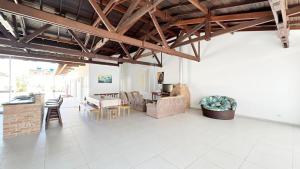 ein Wohnzimmer mit weißen Fliesenböden und Holzdecken in der Unterkunft Casa Mar & Brisa - Wi-fi e piscina in Guaratuba