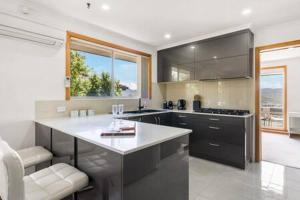 a kitchen with a large island in the middle at Lutana Large house in Hobart