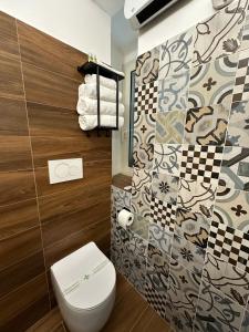 a bathroom with a toilet and a tile wall at Terrazza su Tocco in Tocco da Casauria