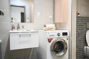 a bathroom with a washing machine and a sink at Lovely Family Suite in Prague