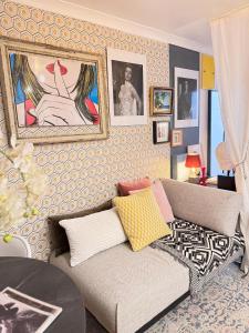 UNIQE 2 Bedroom PRIME LOCATION في لندن: غرفة معيشة مع أريكة وصور على الحائط