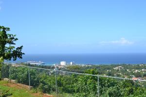 una recinzione su una collina con l'oceano sullo sfondo di Villa De Shalom a Ocho Rios