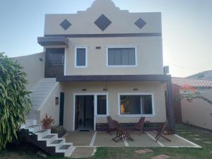 a white house with chairs in front of it at CASAFUERTE departamentos in Luque