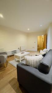 een woonkamer met een bank en een tafel bij Modern 2 Bedroom Apartment- Royal Docks - London City Airport in Londen
