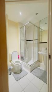 een badkamer met een douche, een toilet en een wastafel bij Modern 2 Bedroom Apartment- Royal Docks - London City Airport in Londen