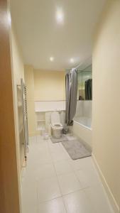 een witte badkamer met een toilet en een bad bij Modern 2 Bedroom Apartment- Royal Docks - London City Airport in Londen