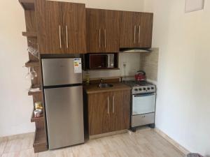 a kitchen with a stainless steel refrigerator and a stove at CASAFUERTE departamentos in Luque