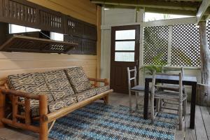 a porch with a couch and a table and a table and a table at Strawberry Fields Together in Robins Bay