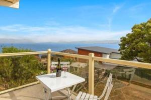 een witte tafel en stoelen op een balkon bij Spacious Modern Home Outstanding Views sleeps 9 in Hobart