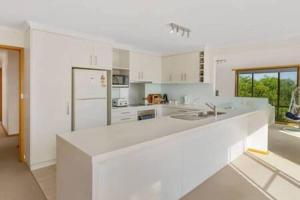 een witte keuken met een groot wit aanrecht bij Spacious Modern Home Outstanding Views sleeps 9 in Hobart