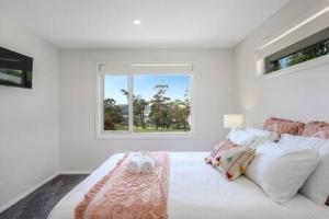 biała sypialnia z łóżkiem i oknem w obiekcie The Rest Retreat Getaway 15 Mins to CBD 3 Bed w mieście Hobart
