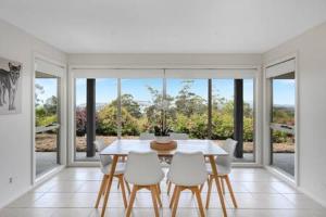 a dining room with a table and white chairs at The Rest Retreat Getaway 15 Mins to CBD 3 Bed in Hobart