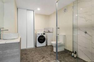 a bathroom with a toilet and a washing machine at The View Studio Apartment Fully self-contained Sandy Bay in Sandy Bay