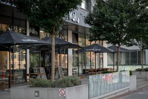 um restaurante com mesas e guarda-sóis em frente a um edifício em Lovely Family Suite em Praga