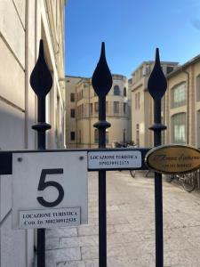 a fence with five signs on it on a street at Arena d'Intorno in Verona