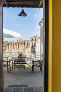 un patio avec une table et des chaises et un bâtiment dans l'établissement Casa vacanze Antica Capua, à Santa Maria Capua Vetere