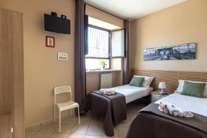 Cette chambre comprend 2 lits et une fenêtre. dans l'établissement Casa vacanze Antica Capua, à Santa Maria Capua Vetere