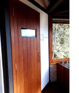 eine Holztür im Bad mit Waschbecken in der Unterkunft Alto de Santa Barbara in São Francisco Xavier