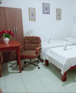 um quarto com 2 camas, uma cadeira e uma secretária em Misti em Tarapoto