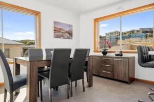 a dining room with a table and chairs and windows at Residence at 165 Great for large groups Sleeps 11 in Hobart