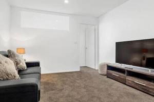 a living room with a couch and a flat screen tv at Residence at 165 Great for large groups Sleeps 11 in Hobart