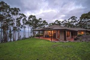 a small house on top of a grassy field at Tinderbox Cliff House - Waterside Private Retreat in Hobart