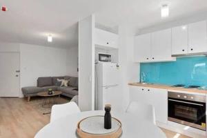 een keuken en een woonkamer met een bank en een tafel bij Renovated unit in leafy surrounds close to shops in Hobart