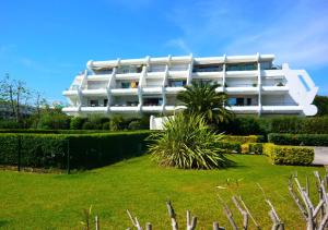 biały budynek z ogrodem przed nim w obiekcie Plage Du Golf - Appartement en rez de jardin secteur Golf MAE-1124 w mieście La Grande-Motte