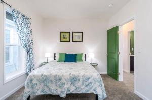 um quarto com uma cama e uma porta verde em Housepitality - The Mint Julep House em Columbus