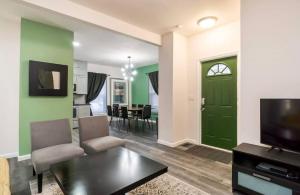 a living room with a green door and a table at Housepitality - The Mint Julep House in Columbus