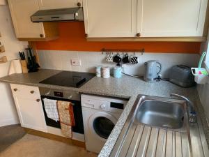 a kitchen with a sink and a washing machine at The Caledonian House in Bath