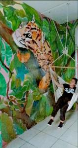 um homem numa rede ao lado de uma pintura de um tigre em Misti em Tarapoto