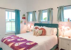 sypialnia z łóżkiem z poduszkami i oknami w obiekcie Ice Cream Retreat at Casa Kumwesu w mieście Bellmead